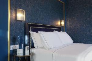 a bedroom with a large bed with white pillows at Pafsilipon Suites in Ermoupoli