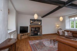 a living room with a couch and a fireplace at Canons Court Lodge in Wotton-under-Edge