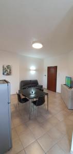 a living room with a table and chairs and a couch at Lovely house tra pineta e mare in Torre di Montalto