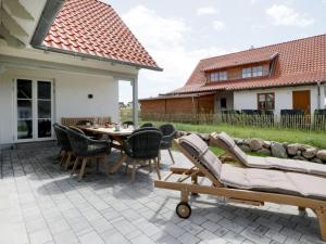 een patio met stoelen en een tafel en een huis bij Strandheimat in Groß Schwansee