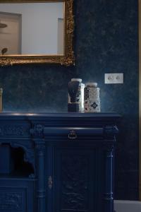a blue cabinet with a mirror on a wall at Pafsilipon Suites in Ermoupoli