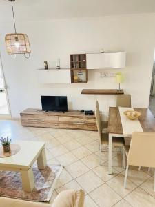 a living room with a table and a tv at Mediterranean Sea Apartments in Durrës