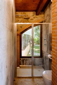 y baño con ducha de cristal y ventana. en Villa La Quercia - Garden&Relax, en Gavorrano