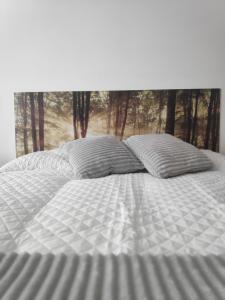Una cama blanca con dos almohadas encima. en Estudio Francés, Parking privado gratuito, en Logroño