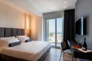 Schlafzimmer mit einem Bett und Meerblick in der Unterkunft Hotel Sporting Riccione in Riccione