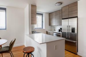 a kitchen with stainless steel appliances and wooden cabinets at 1BR nr Broadway w Indoor pool Gym NYC-28 in New York