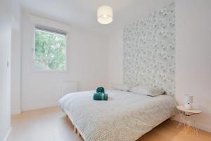 een witte slaapkamer met een bed en een raam bij Appartement Balcon Garage Centre Gare in Nancy