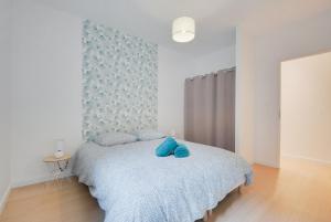 een slaapkamer met een bed met blauwe kussens erop bij Appartement Balcon Garage Centre Gare in Nancy