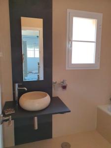 La salle de bains est pourvue d'un lavabo et d'un miroir sur un comptoir. dans l'établissement Villa Ostrero, à Chiclana de la Frontera