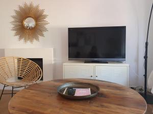 a living room with a table and a flat screen tv at Villa Ostrero in Chiclana de la Frontera
