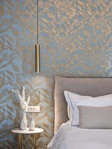 a bedroom with a blue and gold floral wallpaper at Pafsilipon Suites in Ermoupoli
