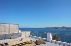 a balcony with a couch and a view of the water at Pafsilipon Suites in Ermoupoli