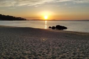 een zonsondergang op een strand met zonsondergang bij Alojamiento de relax y romanticismo ! in Bueu