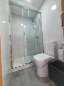 a white bathroom with a shower and a toilet at Alojamiento de relax y romanticismo ! in Bueu