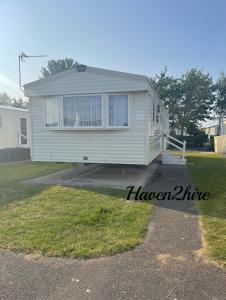 a tiny house is parked in a yard at 8 berth caravan Presthaven Sands in Talacre