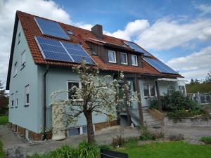une maison avec des panneaux solaires sur le toit dans l'établissement Pension "Der Sulzbachhof", à Lehrberg