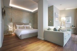 a bedroom with a bed and a couch at Pafsilipon Suites in Ermoupoli
