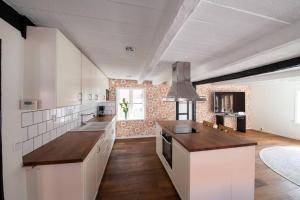 cocina grande con armarios blancos y fogones en Entire house in the center en Ystad