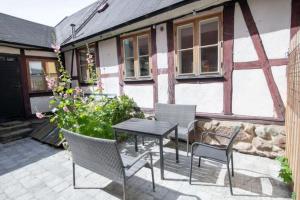 a patio with a table and chairs in front of a house at Entire house in the center in Ystad