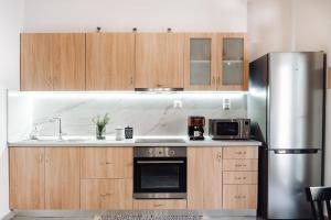 a kitchen with wooden cabinets and a stainless steel refrigerator at Achilleas cozy house in Prinés