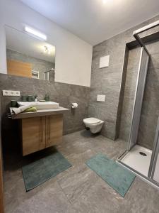 uma casa de banho com um lavatório, um WC e um chuveiro em Alpenflair em Berwang