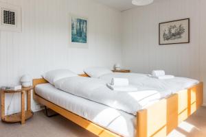 Cette chambre comprend 2 lits avec des draps blancs. dans l'établissement Chalet Lienzhubel - GRIWA RENT AG, à Grindelwald