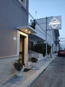 a building with a sign on the side of a street at Albergo Primavera in Porto Cesareo