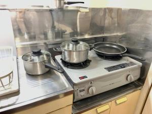 two pots and pans on a stove in a kitchen at メゾン八千代102 in Tokyo +17 photos
