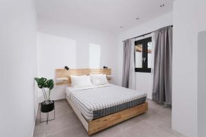 um quarto com uma cama num quarto branco em Euphoria Luxury Apartment em Matala