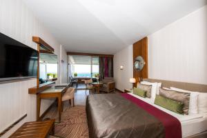 シダにあるSide Star Elegance Hotel - Ultra All Inclusiveのベッド、デスク、テレビが備わるホテルルームです。