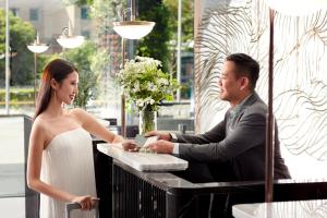 um homem e uma mulher em frente a um registo em Momentus Hotel Alexandra em Singapura