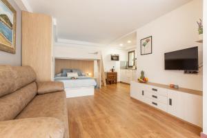 ein großes Wohnzimmer mit einem Sofa und einem Bett in der Unterkunft Armonia estudio, comparte exterior in Llinars del Vallès