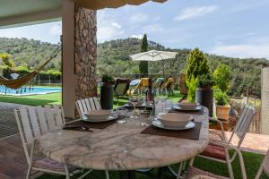 una mesa de madera con copas de vino y sillas en el patio en Armonia estudio, comparte exterior, en Llinars del Vallès