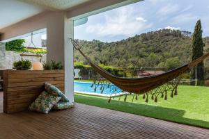 eine Hängematte auf einer Veranda mit Poolblick in der Unterkunft Armonia estudio, comparte exterior in Llinars del Vallès