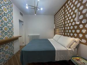 Un dormitorio con una cama en una habitación con una pared. en Taonasi Taormina City Apartment, en Taormina