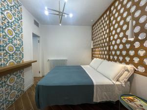 Un dormitorio con una cama en una habitación con una pared. en Taonasi Taormina City Apartment, en Taormina 22 fotos más