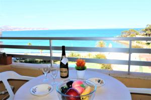 stół z butelką wina i miską owoców w obiekcie 56C Vora vistas al mar parking y wifi w mieście Calpe