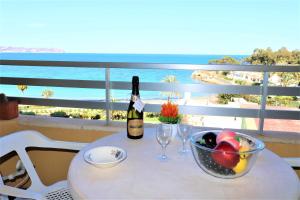 stół z butelką wina i miską owoców w obiekcie 56C Vora vistas al mar parking y wifi w mieście Calpe