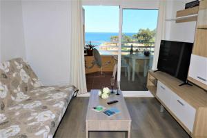salon z kanapą, telewizorem i stołem w obiekcie 56C Vora vistas al mar parking y wifi w mieście Calpe