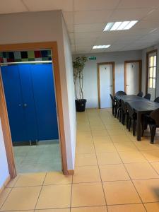 sala konferencyjna ze stołem, krzesłami i niebieskimi drzwiami w obiekcie HOSTEL Cangas w mieście Cangas de Morrazo