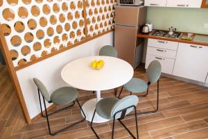 cocina con mesa blanca y sillas en Taonasi Taormina City Apartment, en Taormina