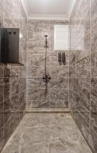 W łazience znajduje się prysznic ze ścianą wyłożoną kafelkami. w obiekcie Manu Startup House w Stambule