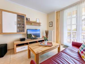 ein Wohnzimmer mit einem TV und einem Tisch in der Unterkunft Residenz am Balmer See - BS 36 mit Wellnessbereich in Balm