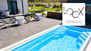 a swimming pool in a yard with a patio and a house at Loox Ostrovo- Boutique House-noclegi nad morzem in Ostrowo
