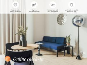 a living room with a blue couch and a table at UNITY Helsinki in Helsinki