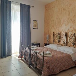 a bedroom with a large bed and a window at Mediterraneo Camere in Otranto