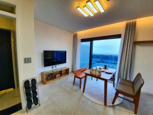 a living room with a table and a television at Nolgureum private pool villa in Jeju