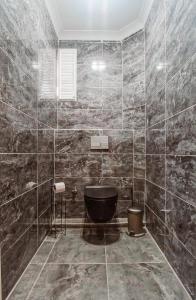 a bathroom with a black tub and marble walls at Manu Startup House in Istanbul