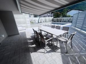 un patio con mesa, sillas y piscina en VILLA CLAUDIA WITH PRIVATE POOL, en Colico