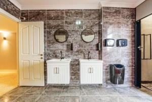 La salle de bains est pourvue de 2 lavabos et de 2 miroirs. dans l'établissement Manu Startup House, à Istanbul